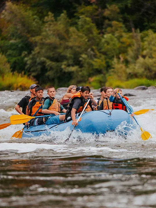 A raft full of paddlers taking whitewater on the Bhotekoshi