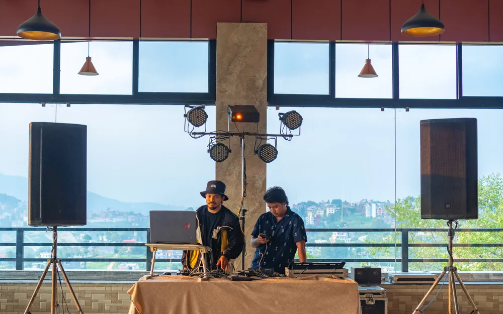 A DJ booth set up against the window wall